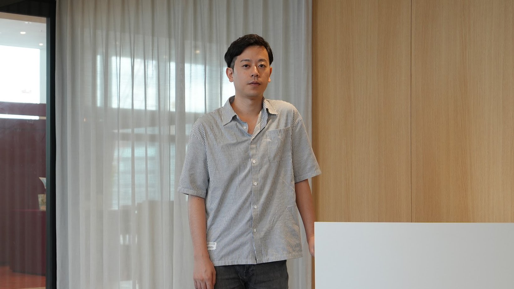 Takeshi Okada standing on an upper floor of a Recruit office